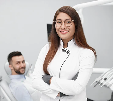 Dra. Alice Vieira olhando sorrindo e de braços cruzados